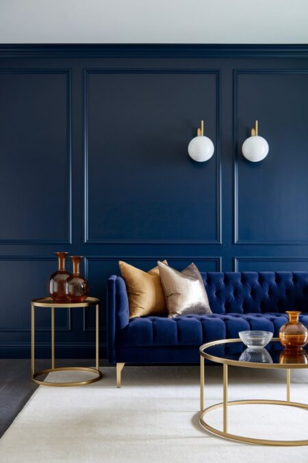 glamorous navy blue living room with a tufted sofa and gold accents