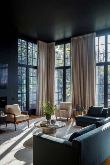 luxury dark living room with large floor-to-ceiling windows and warm ivory drapes