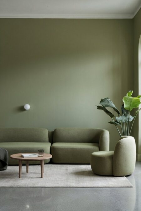 sage green minimalist living room with low-profile seating and polished concrete flooring