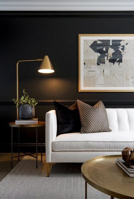 black and white living room with a brass picture frame, coffee table, and a lamp