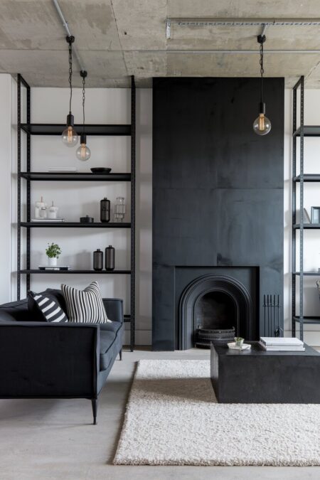 industrial black and white living room with a fireplace and Edison-bulb pendant lights