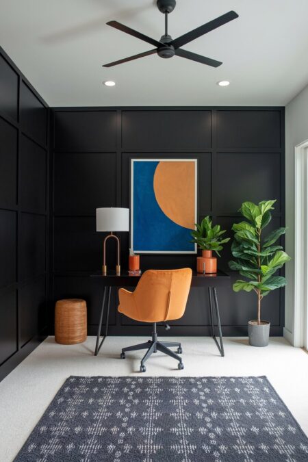 modern black home office with pops of mustard yellow in artwork and chair, a black ceiling fan