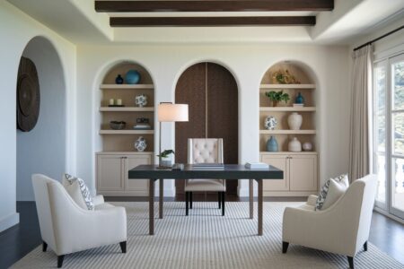 Mediterranean style home office with arched alcoves, two armchairs, and ceiling beams
