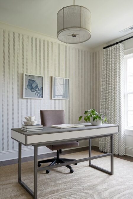 transitional home office with a subtle wallpaper and a gray office chair