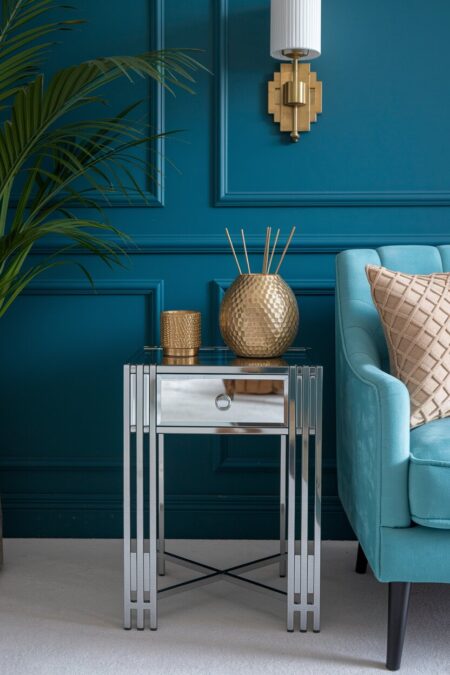 Art Deco living room with a mirrored chrome side table, a light blue armchair, and brass accents