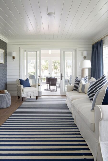 coastal living room with a striped rug and throw pillows in navy and white