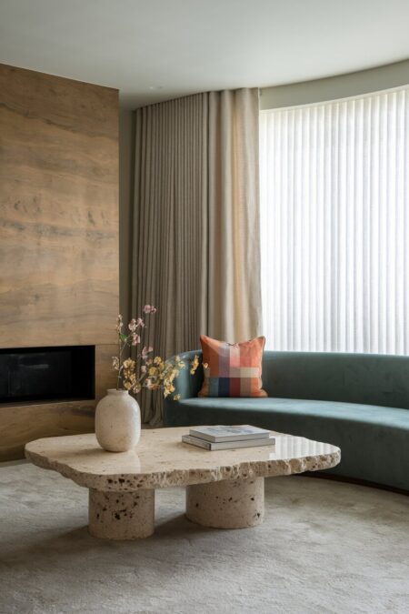 contemporary living room with a raw edge travertine coffee table and built-in electric fireplace