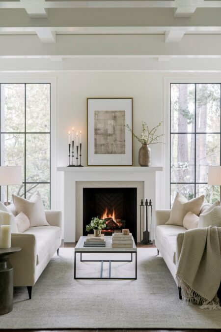 contemporary neutral romantic living room with a fireplace and tall pillar candles on the mantel