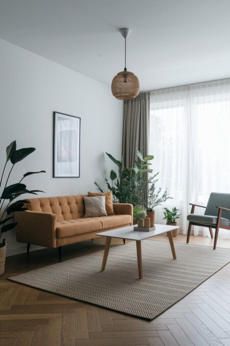 Scandinavian living room with a subtle herringbone weave rug and muted orange sofa