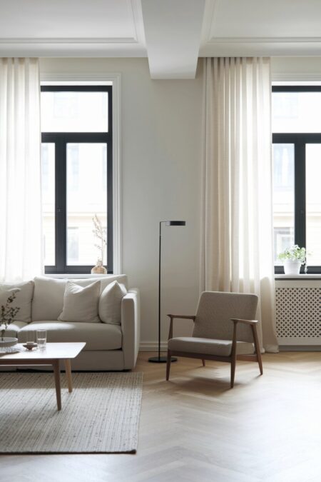 Scandinavian living room with black framed windows and a slim black floor lamp