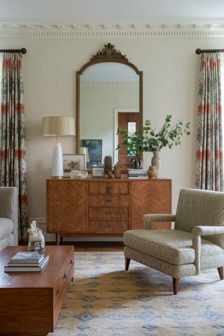 vintage living room with a Victorian mirror, a mid-century credenza, and an upholstered lounge chair